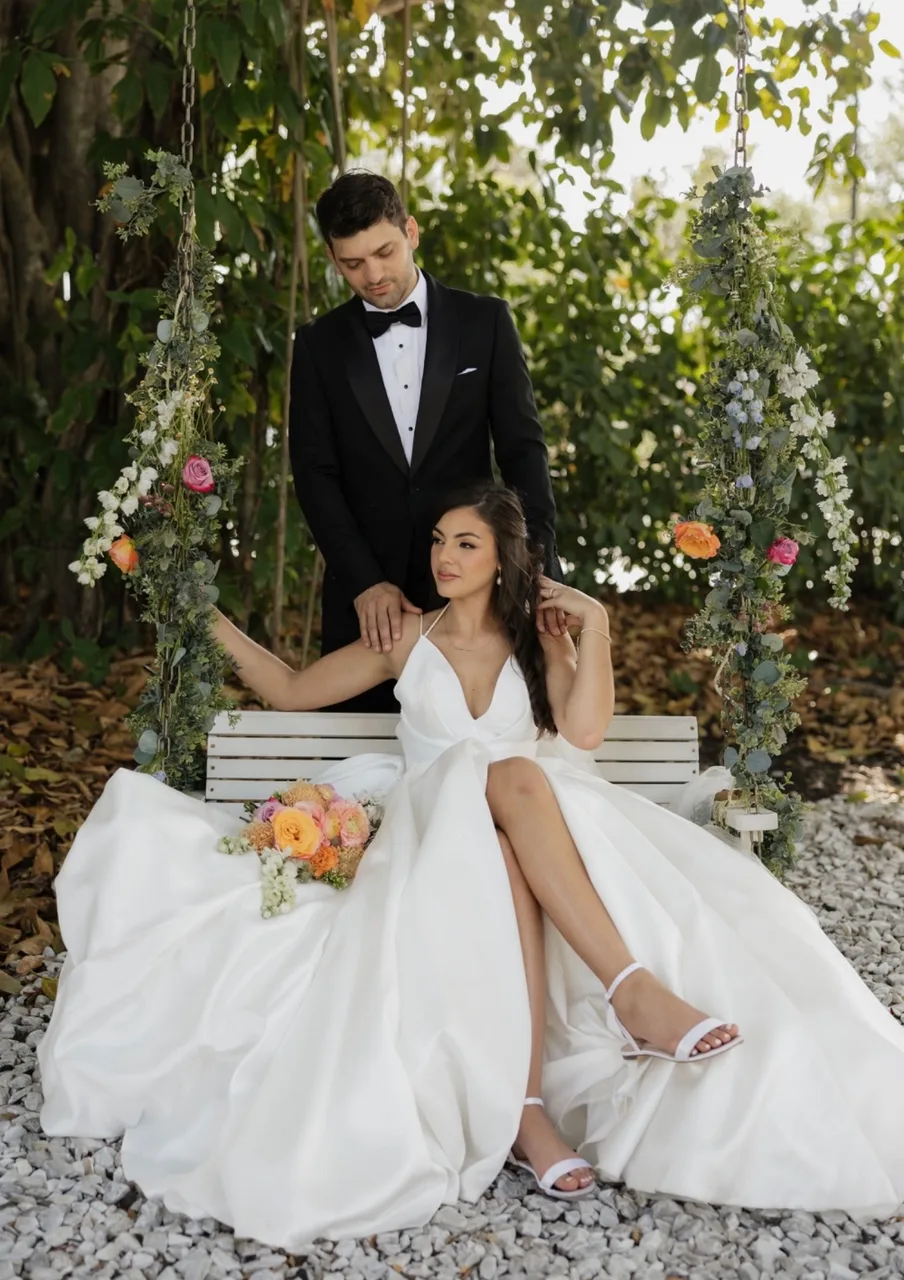 Couple sharing a romantic moment on a flower-adorned swing
