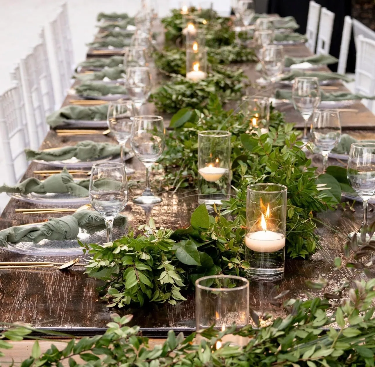 Elegant reception table with greenery centerpiece and candlelight